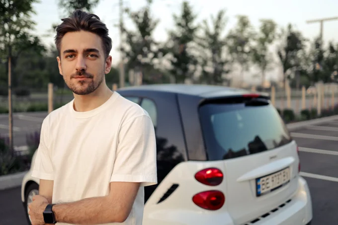 Chico joven delante de su coche