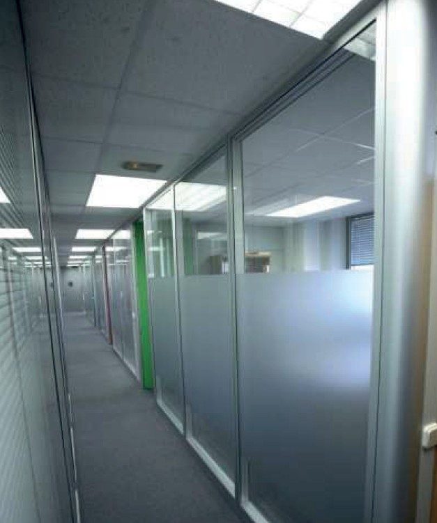 Pasillo con mamparas de oficina de cristal viniladas